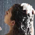 Femme sous la douche qui se fait un shampooing