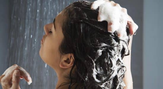 Femme sous la douche qui se fait un shampooing