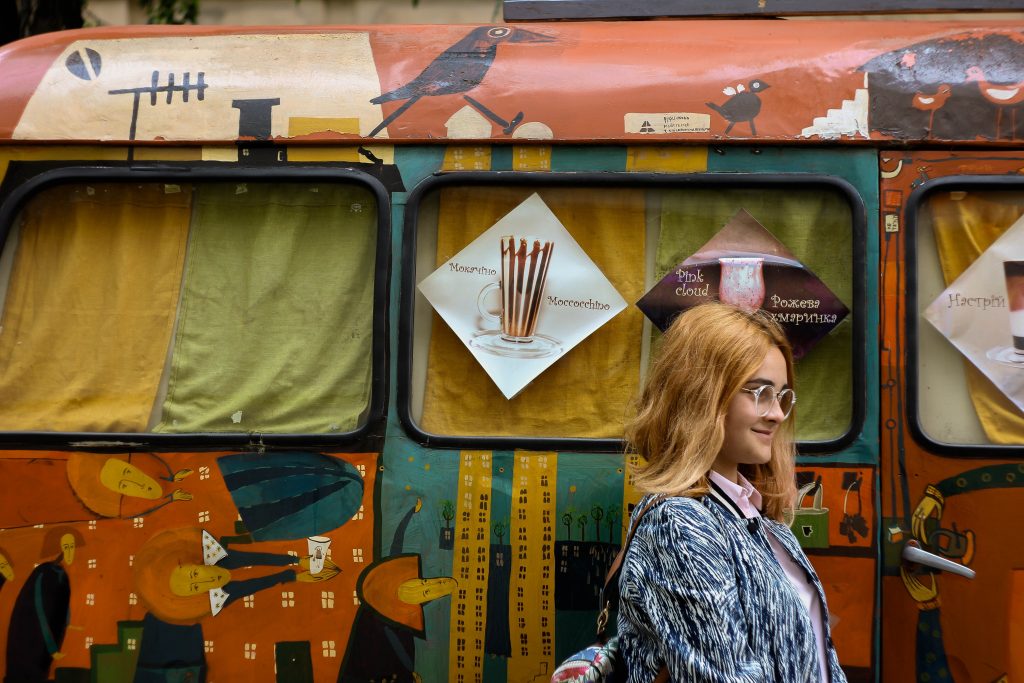 jeune femme rousse devant un van peint